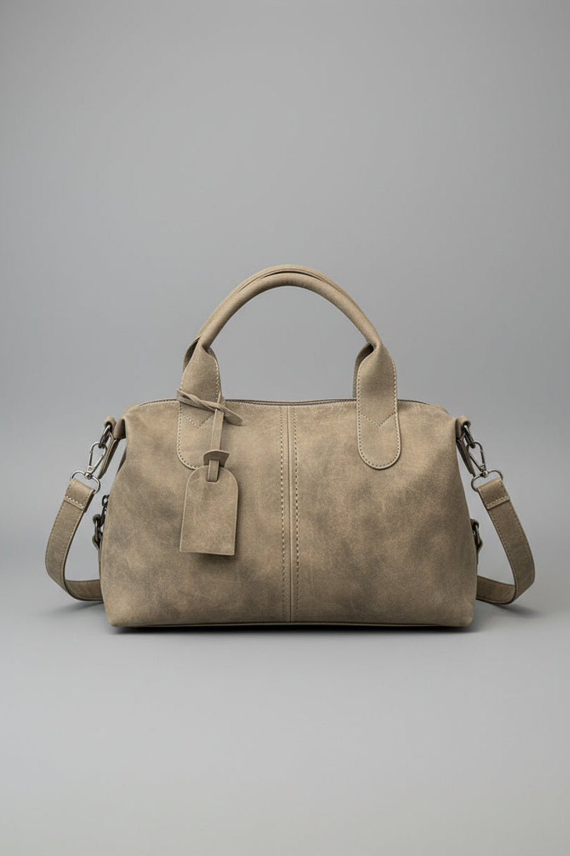 Beige handbag on a dark surface with 'EVEN' branding in the background
